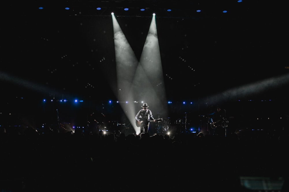 man in black suit standing on stage