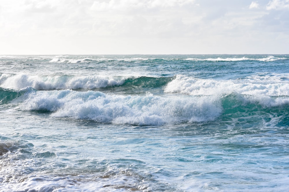 ocean waves under white sky during daytime