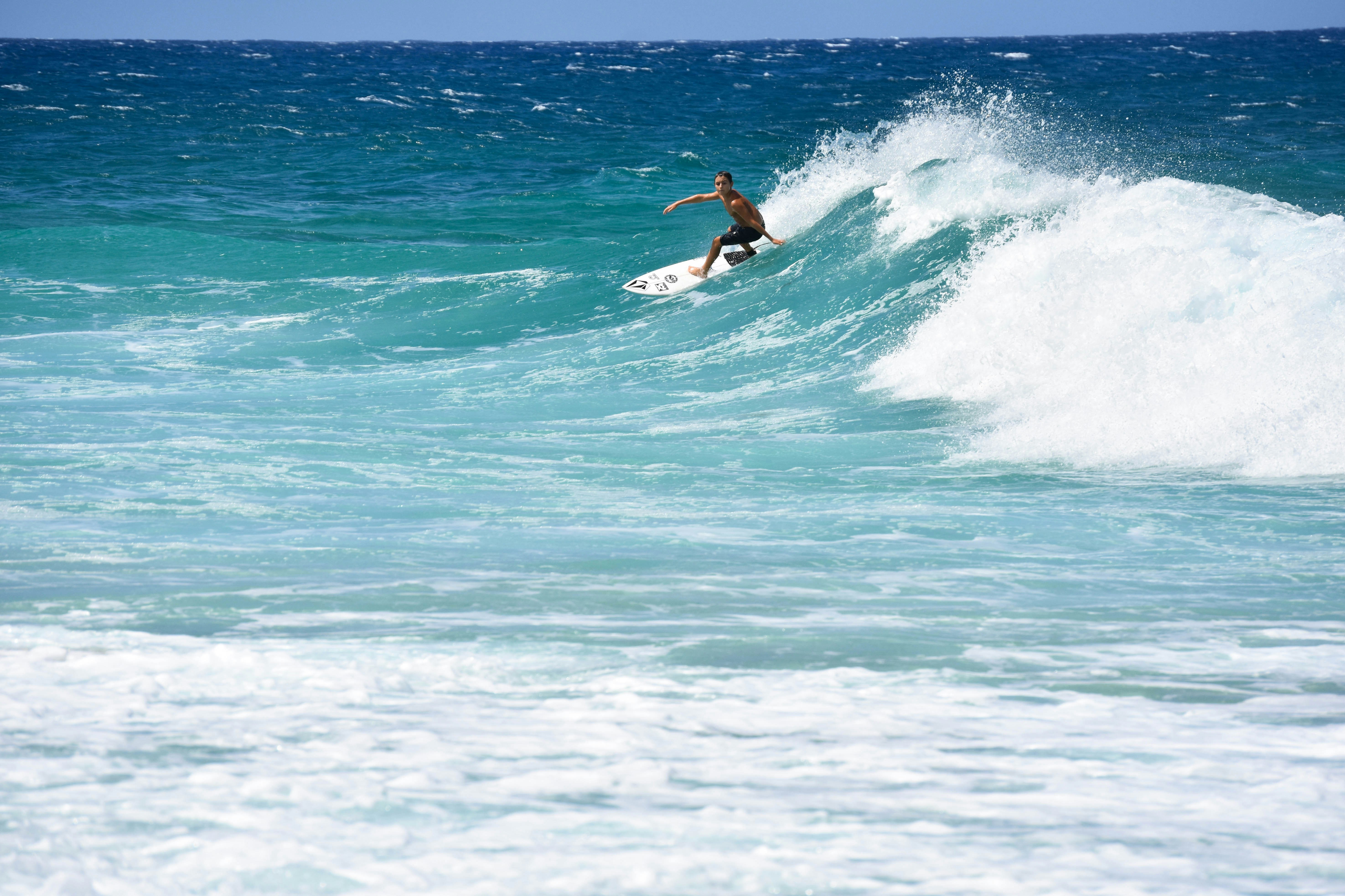 homme surfant sur les vagues de la mer pendant la journée