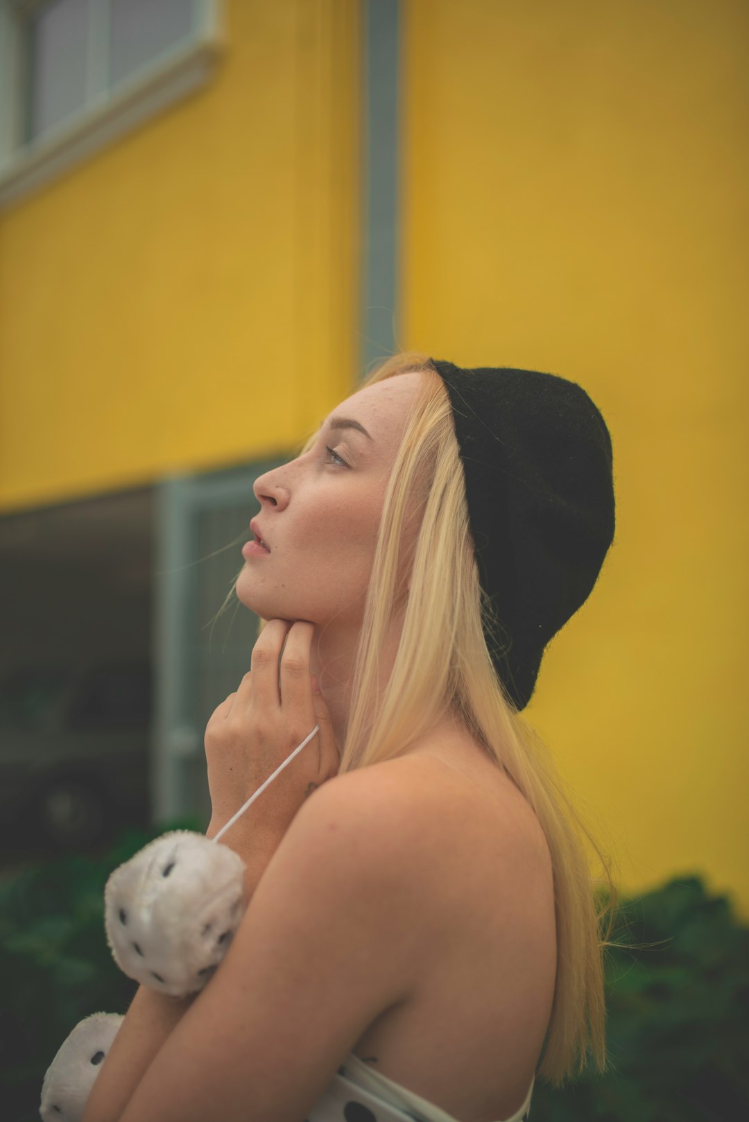 woman in black hat looking at white bird