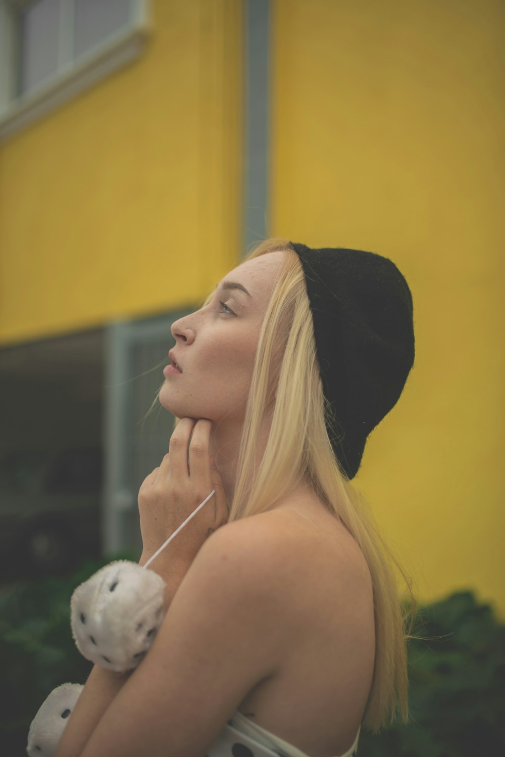 Mujer con sombrero negro mirando pájaro blanco