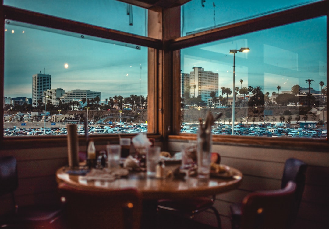 brown wooden table with chairs near body of water during night time