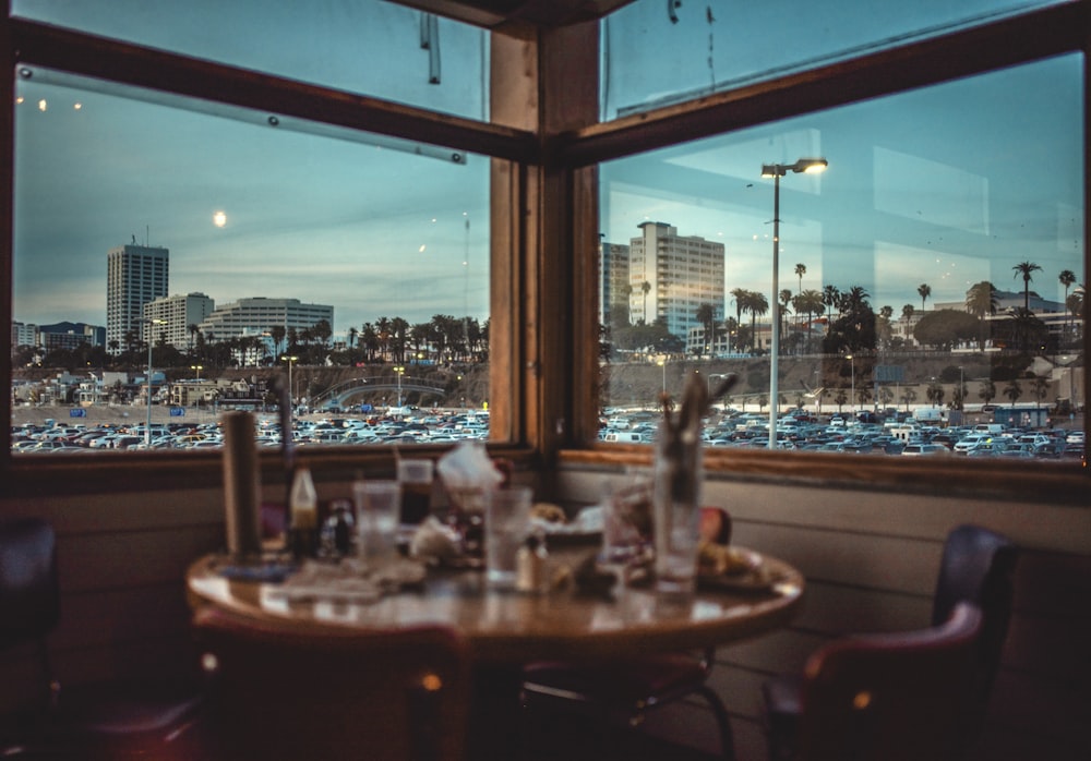 brown wooden table with chairs near body of water during night time