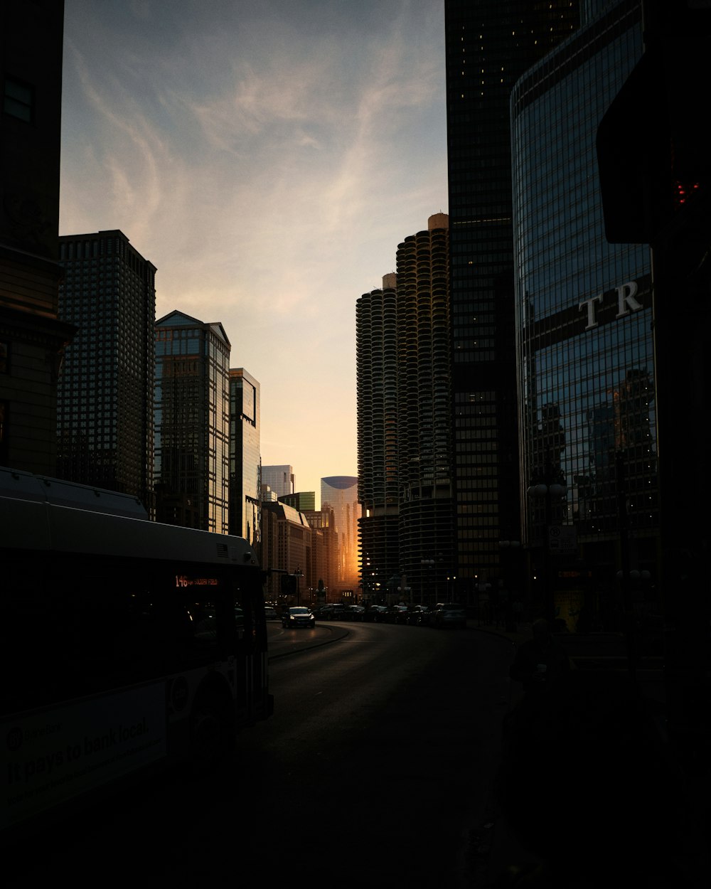 cars on road between high rise buildings during daytime