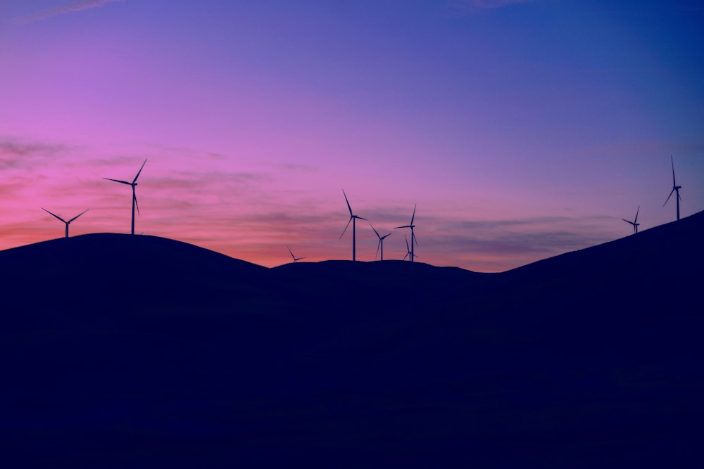 wind turbines on hill during dusk