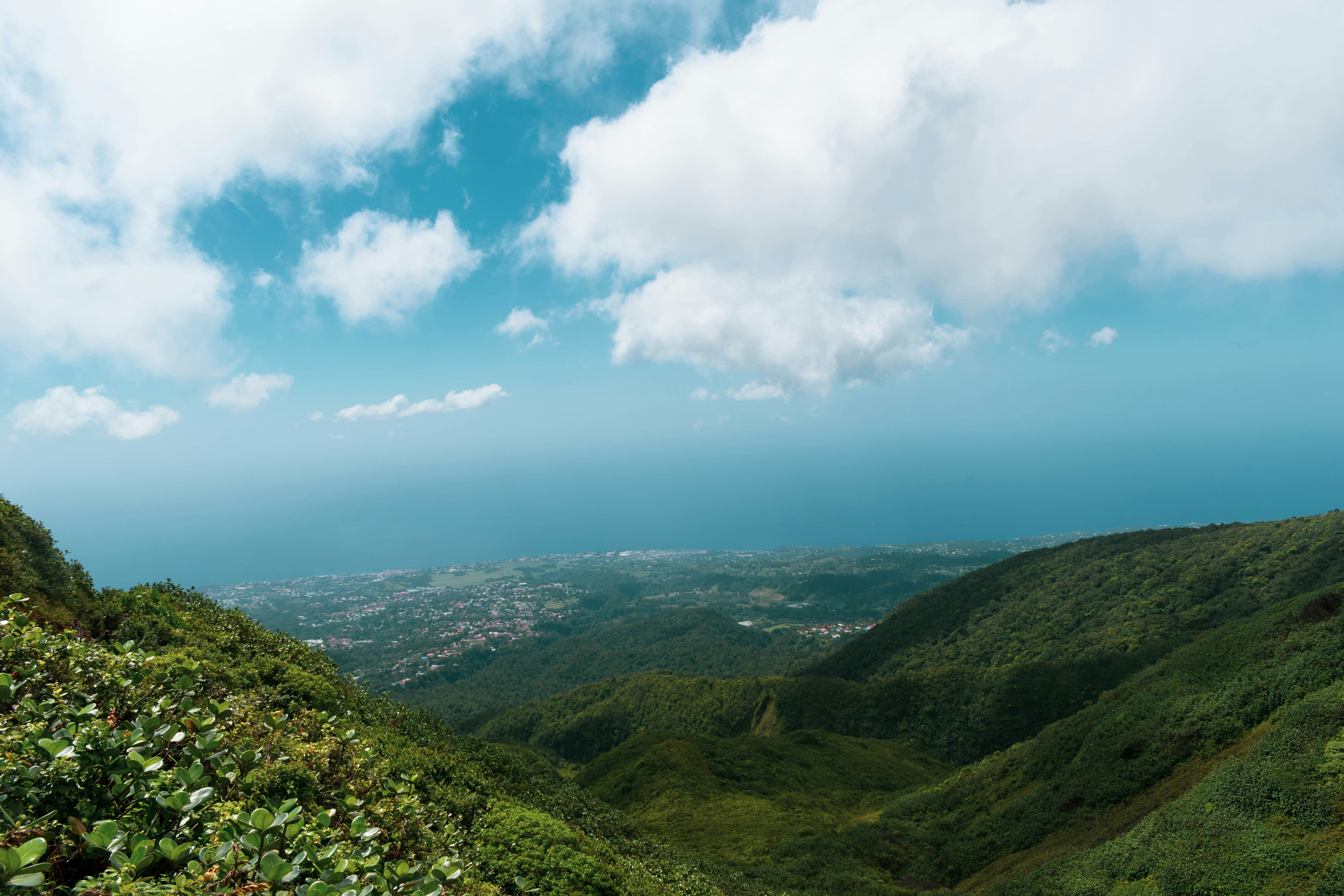 green mountains under white clouds and blue sky during daytime, View of the City of Saint Claude from the Soufriere trace at 1000m of altitude