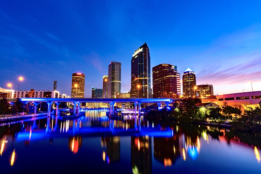 city skyline across body of water during night time