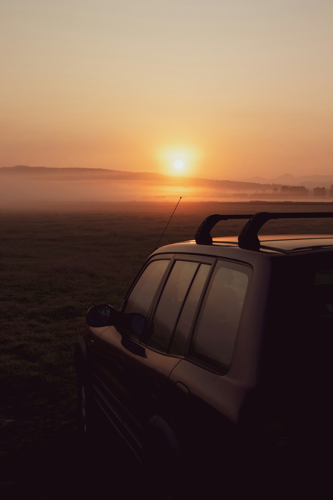 black suv on black sand during sunset