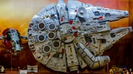 High-definition photo of a Millennium Falcon toy with intricate detailing and weathered paint.
