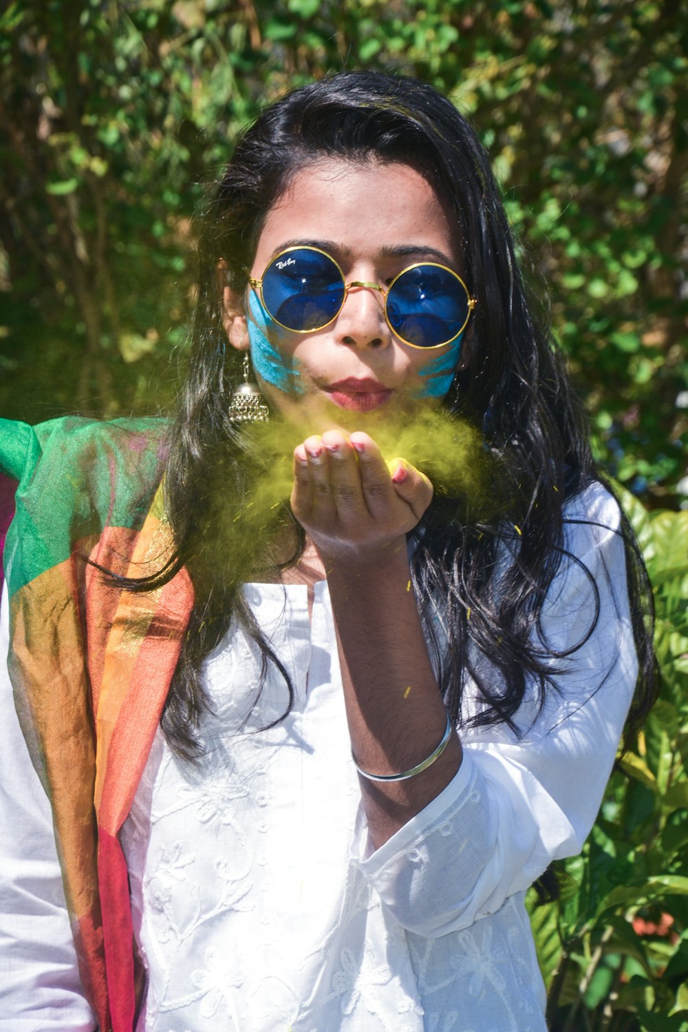 woman in white and red shirt wearing blue sunglasses