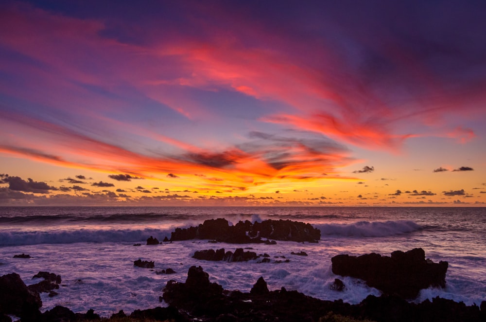 ocean waves crashing on rocks during sunset