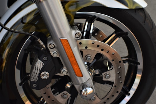 Close-up of a mechanic examining a motorcycle's brake system