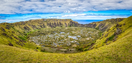 green grass field and mountain under blue sky during daytime in Rano Kau Chile