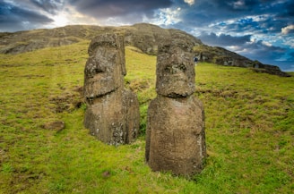 brown stone formation on green grass field during daytime