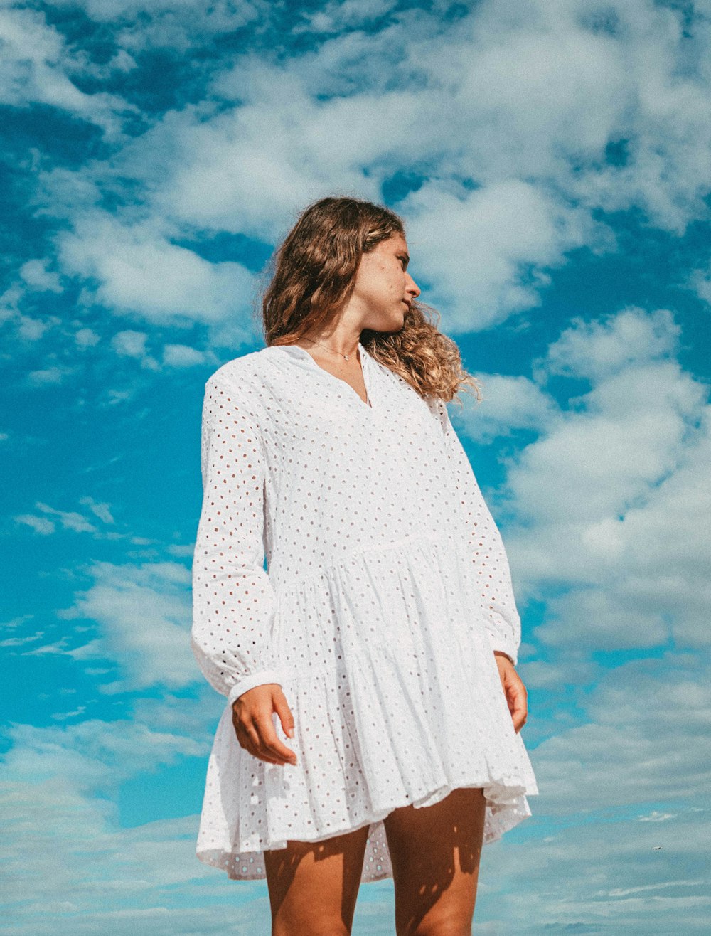 woman in white long sleeve dress standing under blue sky during daytime
