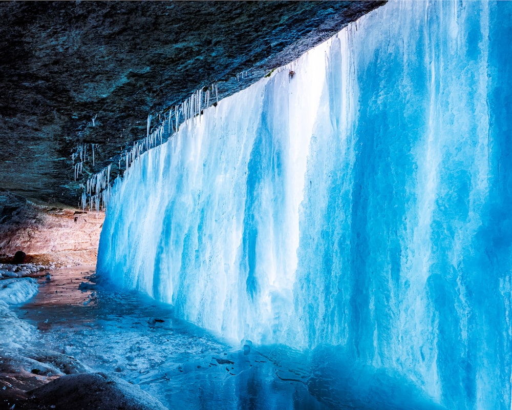 grotte brune et blanche près du plan d’eau pendant la journée