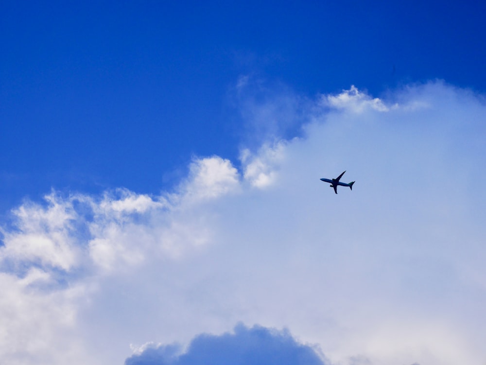 black airplane flying in the sky during daytime