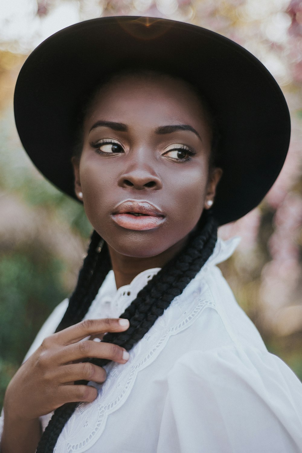 woman in white dress shirt wearing black hat