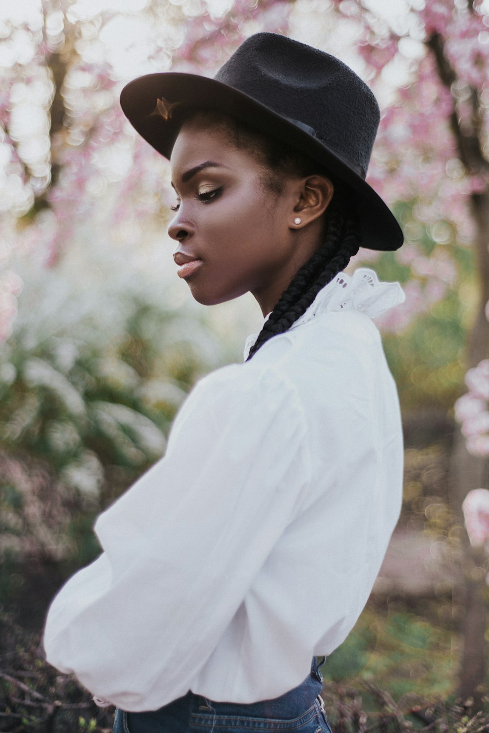Mujer con camisa blanca de manga larga y sombrero negro