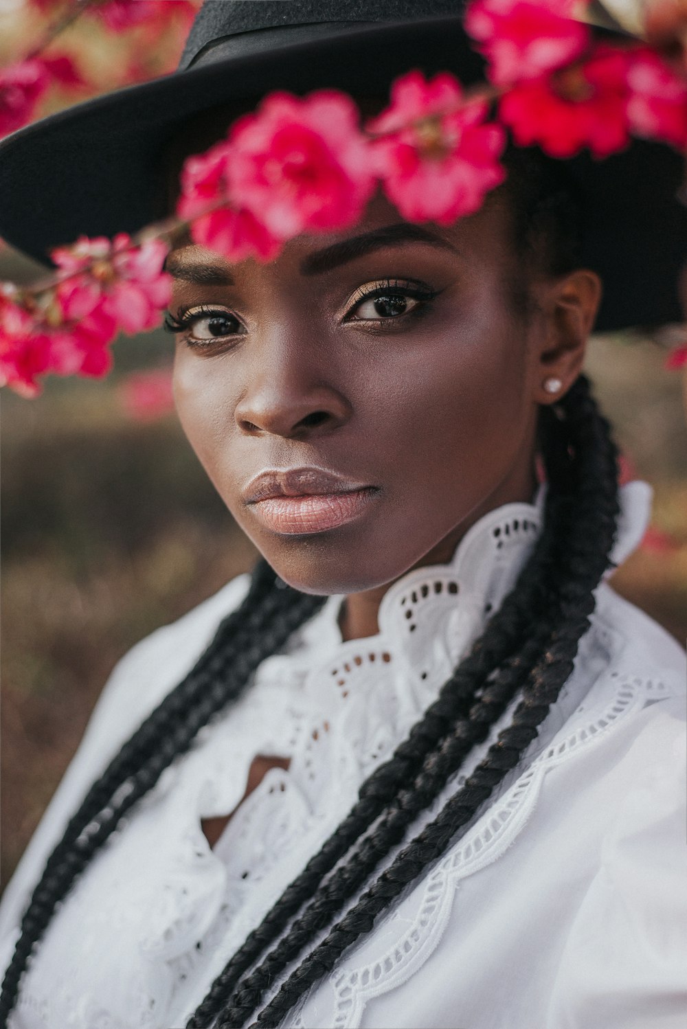 woman in white shirt with pink flower on head