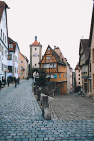 A charming cobblestone street in a historic European town bustling with life.