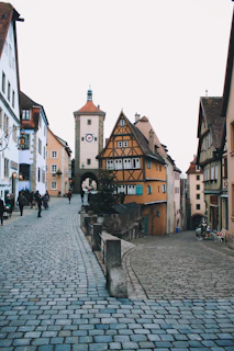 A charming cobblestone street in a historic European town bustling with life.