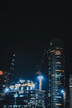 Modern building under construction with futuristic cranes and lights.