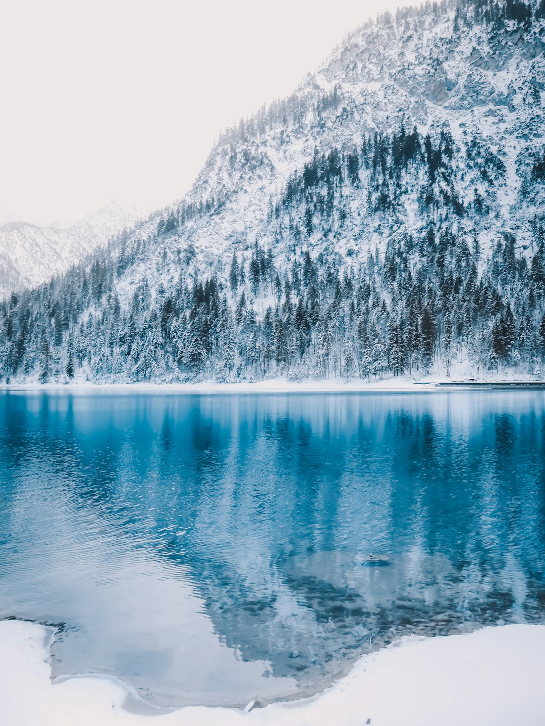 body of water near mountain during daytime