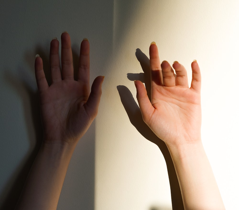 persons hand on white wall