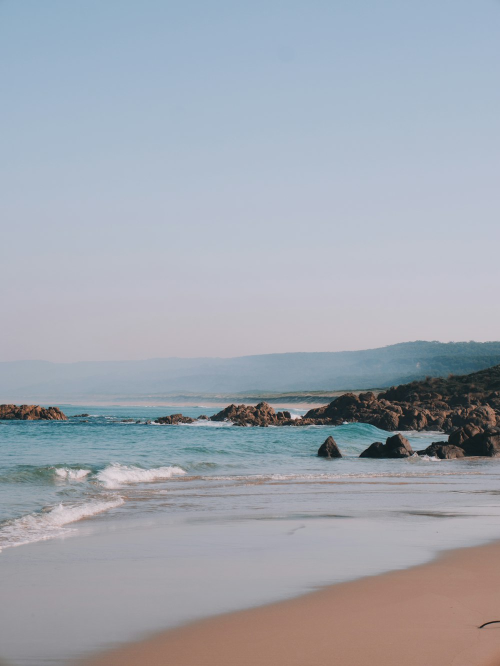 ocean waves crashing on shore during daytime