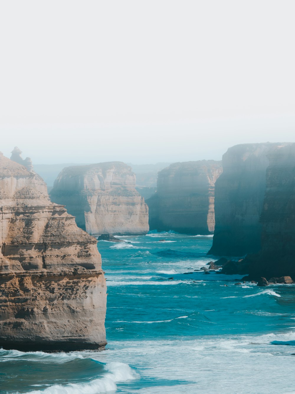 Montagne Rocheuse brune au bord de la mer pendant la journée