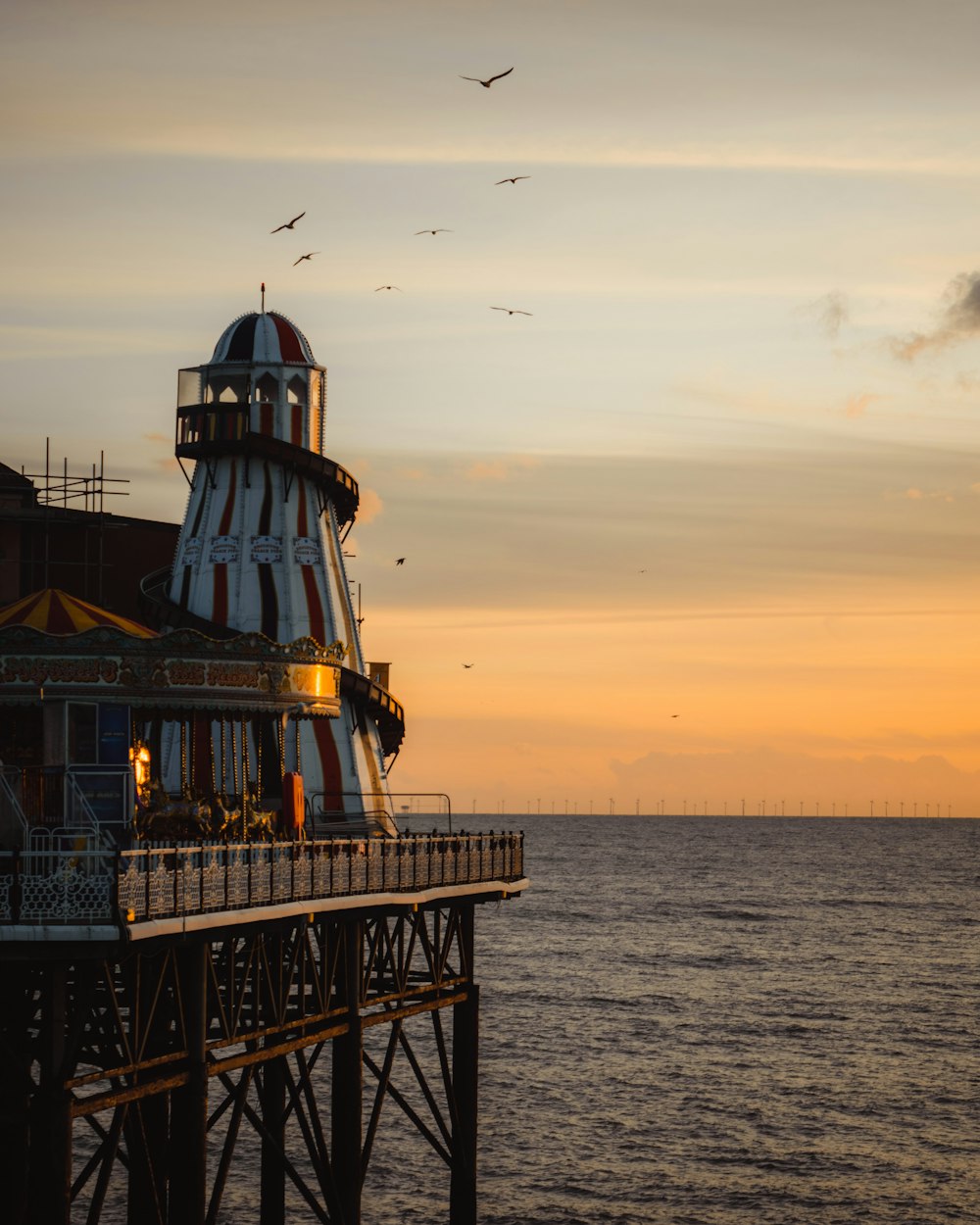 black and white lighthouse on sea during sunset