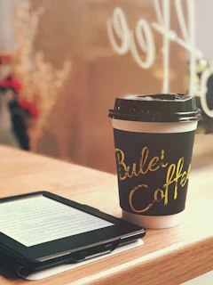 black and yellow coffee cup on brown wooden table
