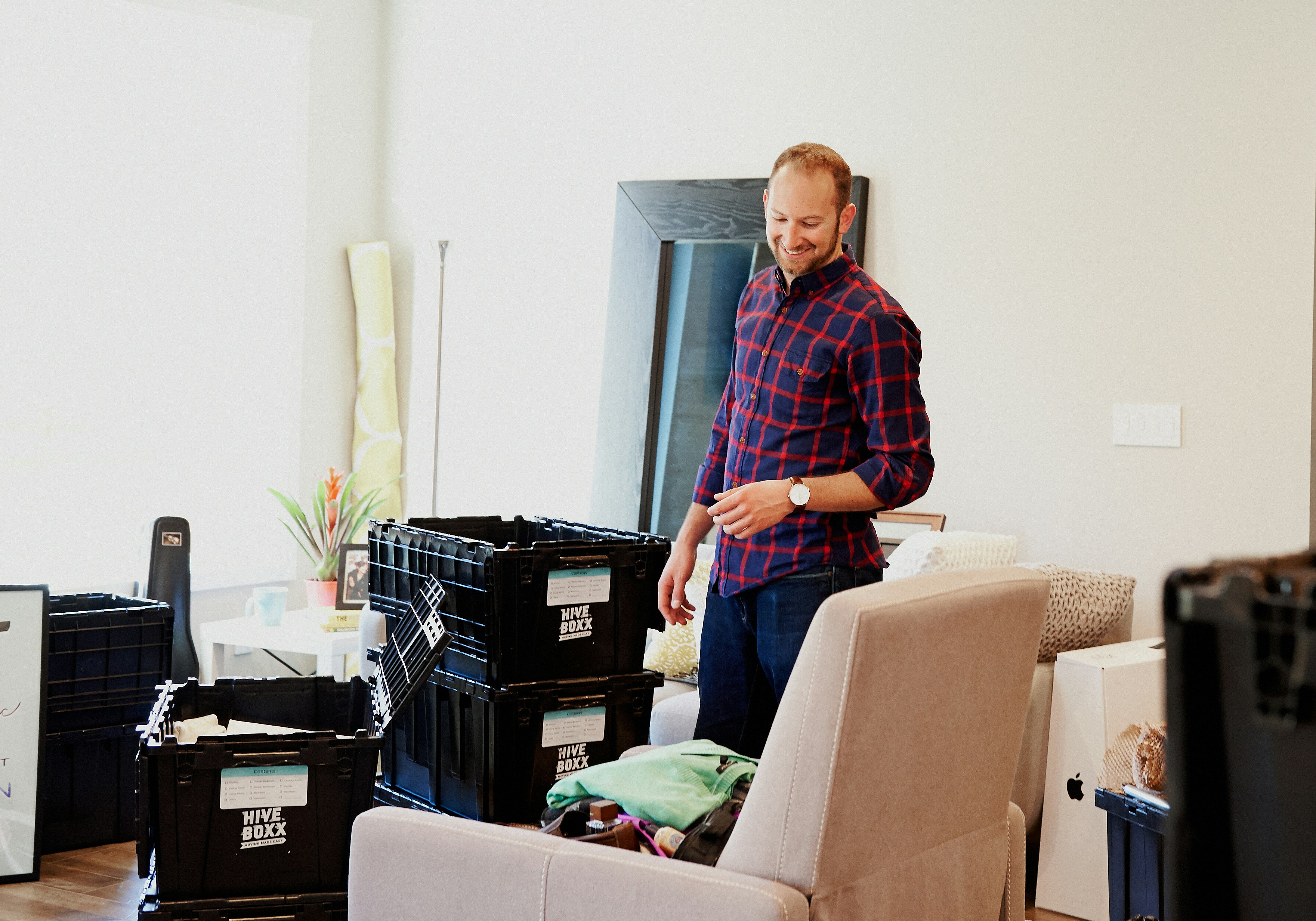 How to Declutter Your Home Without Feeling Overwhelmed – man in red blue and white plaid dress shirt and blue denim jeans standing beside black