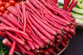 A basket filled with bright orange carrots and other fresh vegetables.