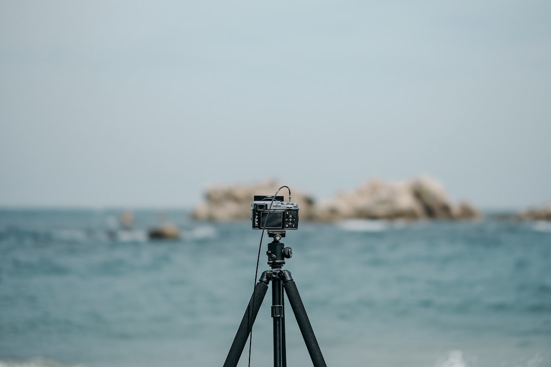 black and silver camera on tripod on beach shore during daytime