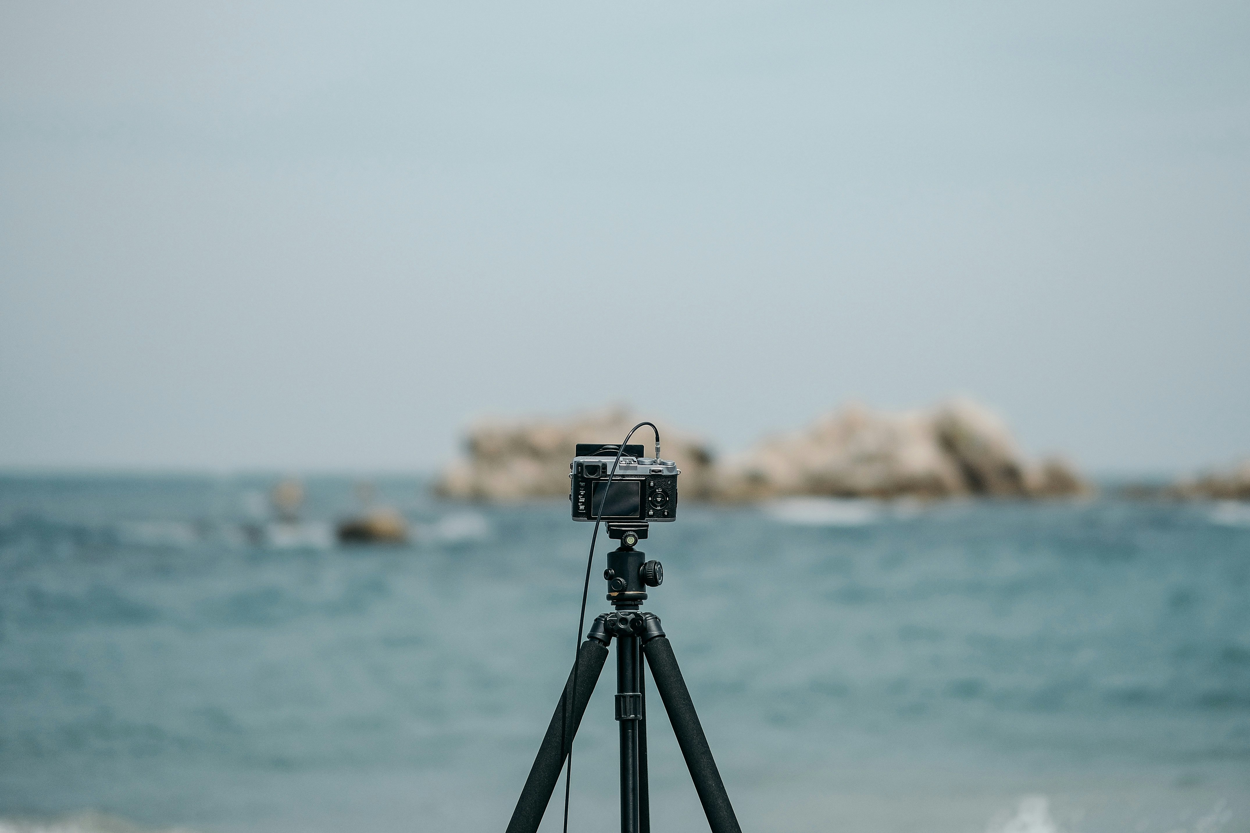 black and silver camera on tripod on beach shore during daytime