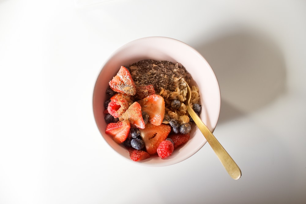 white ceramic bowl with food and brown wooden spoon