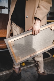 person holding brown wooden frame