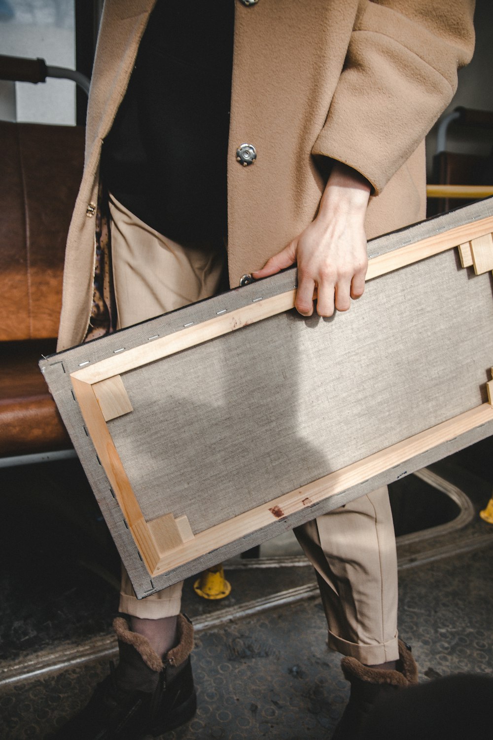 person holding brown wooden frame