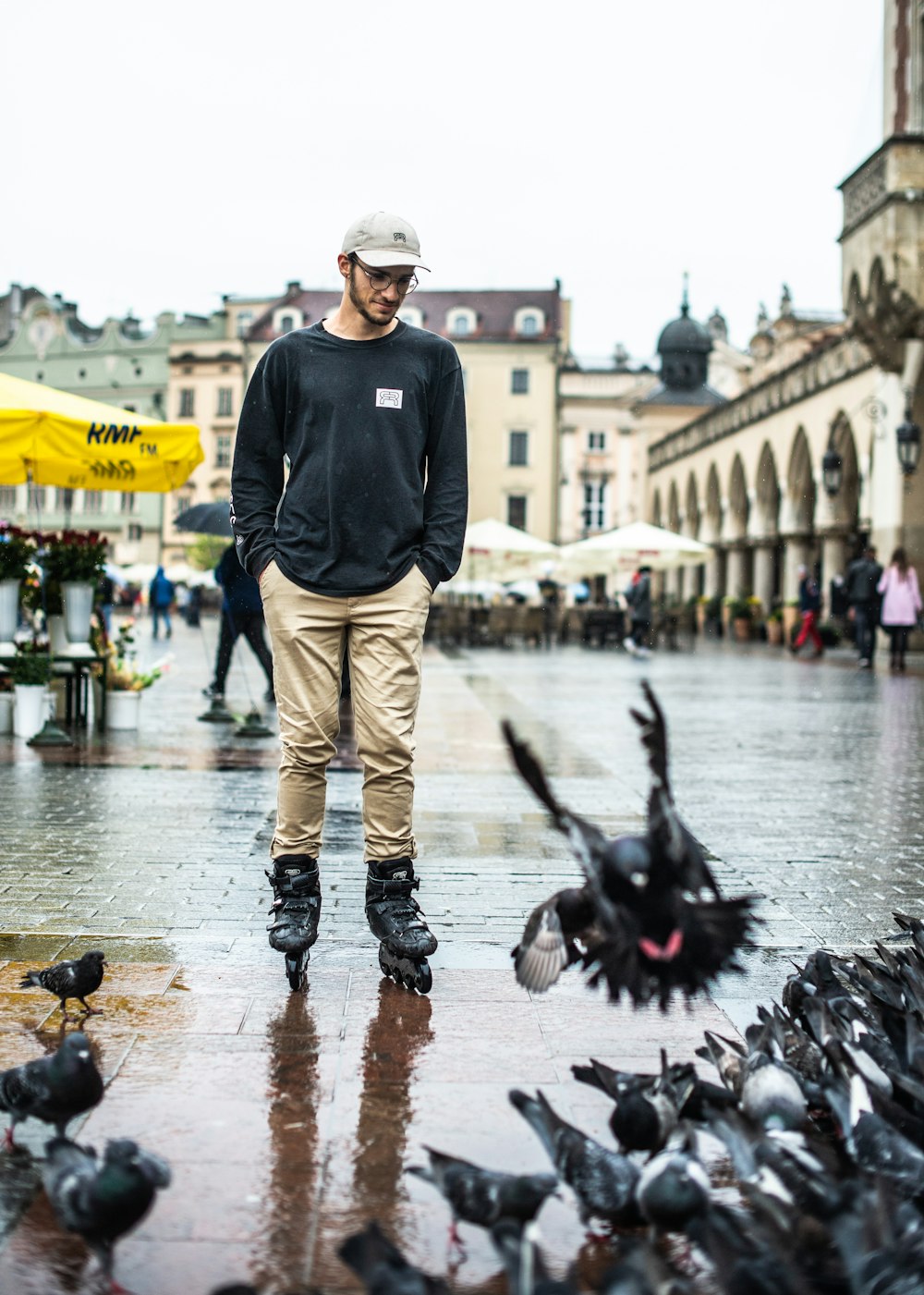 a man standing in the middle of a bunch of pigeons