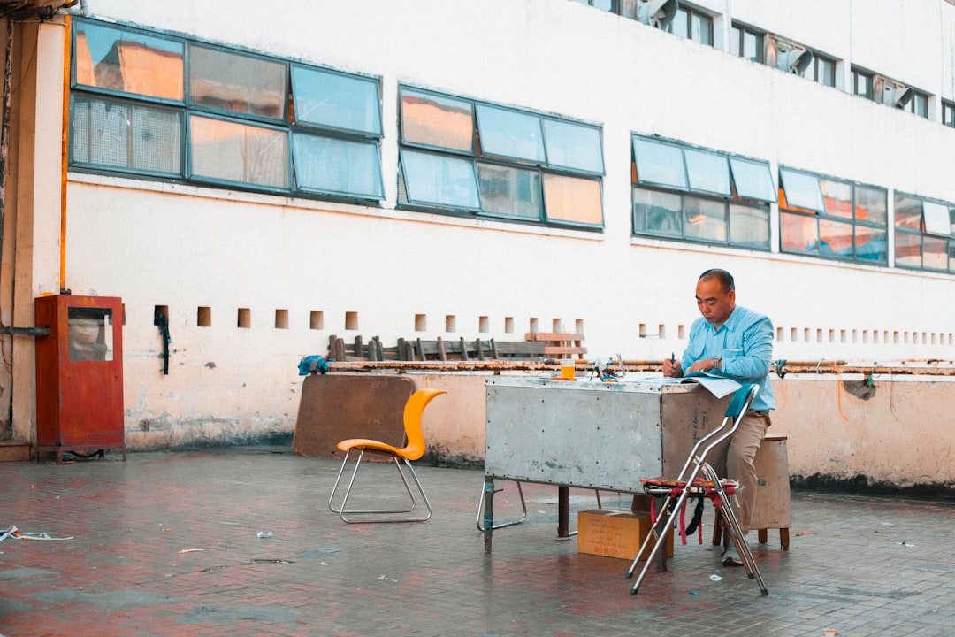 man in blue polo shirt sitting on chair in front of table