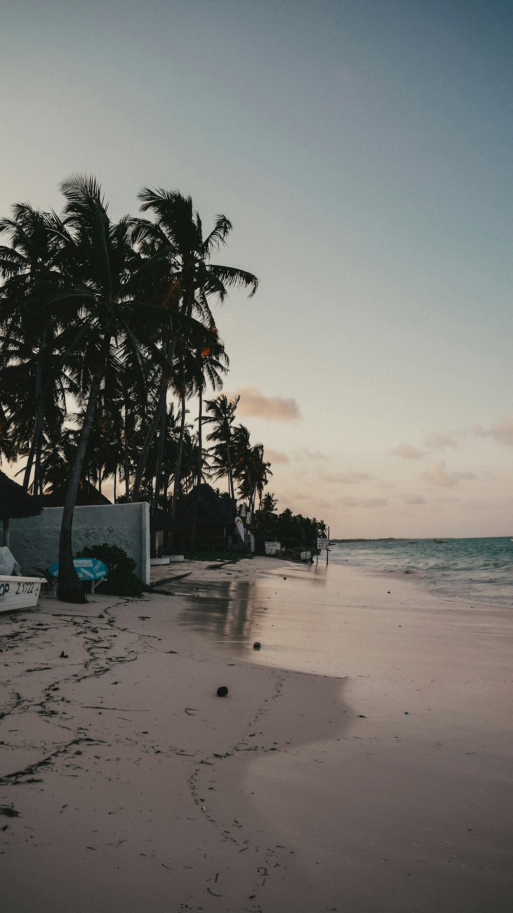 white and blue wooden boat on beach during sunset