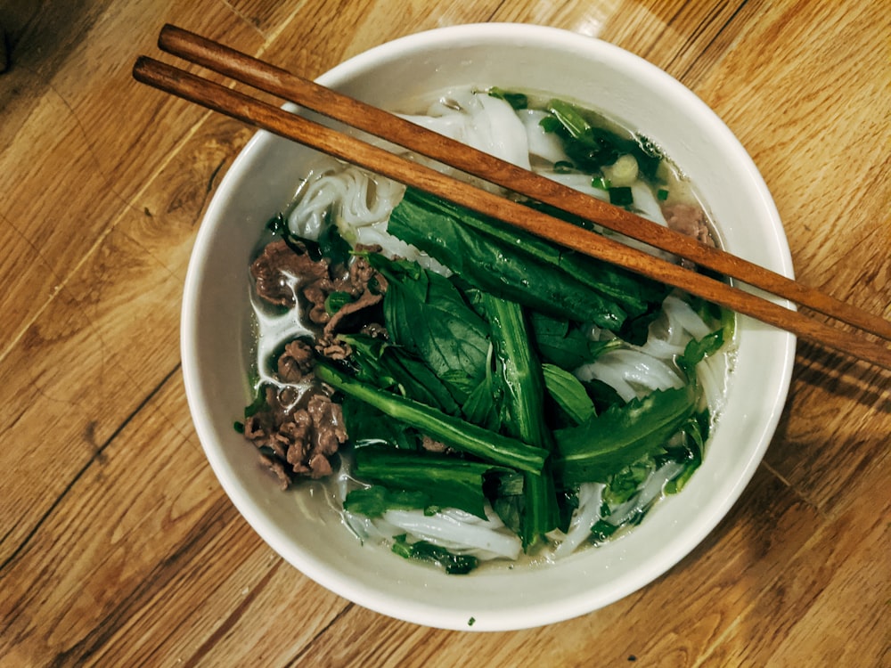 brown wooden chopsticks on white ceramic bowl