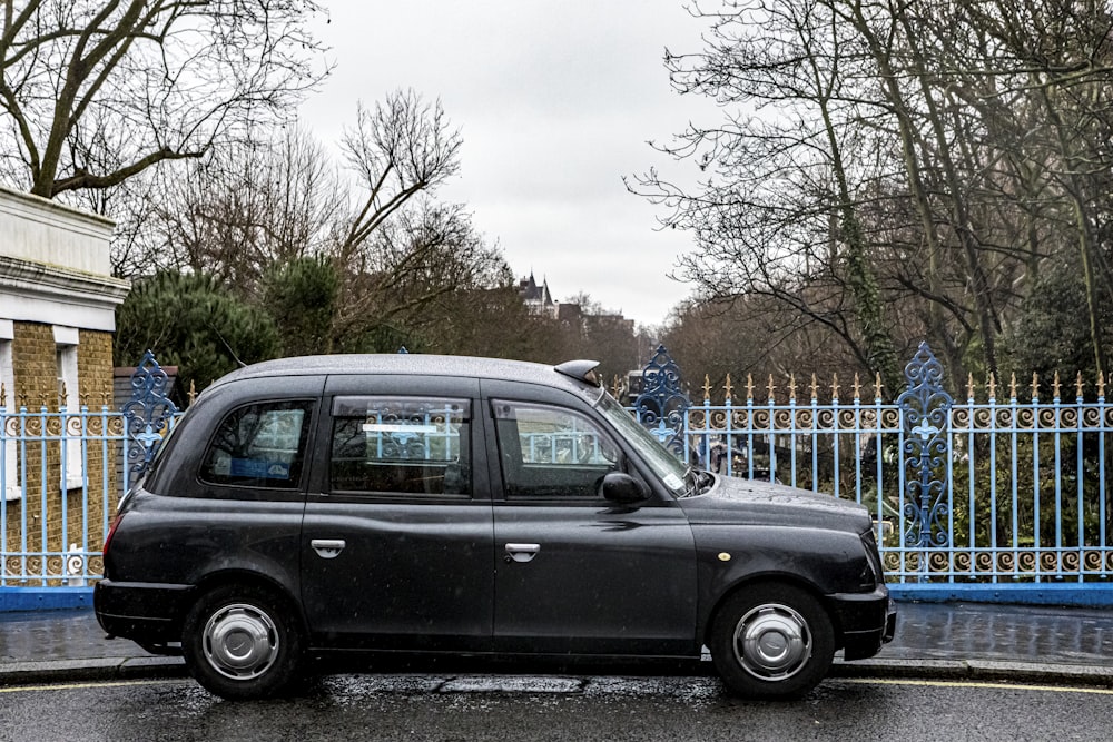 black station wagon parked near fence during daytime