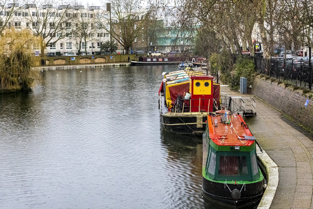 green and orange boat on river during daytime