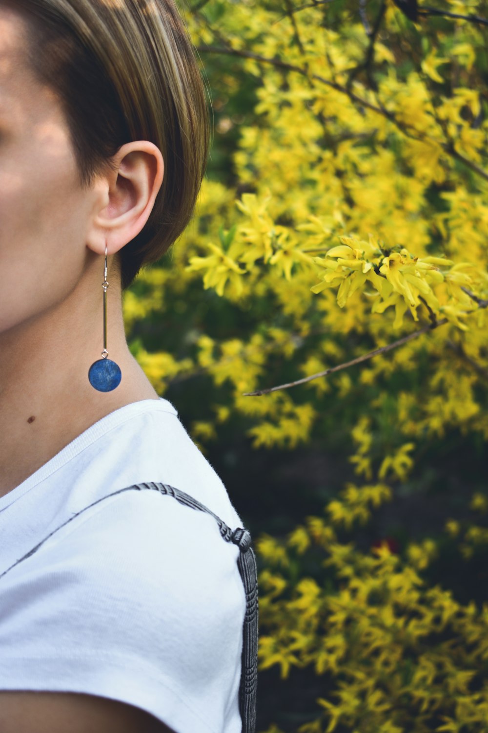 Femme en chemise blanche portant une boucle d’oreille en argent