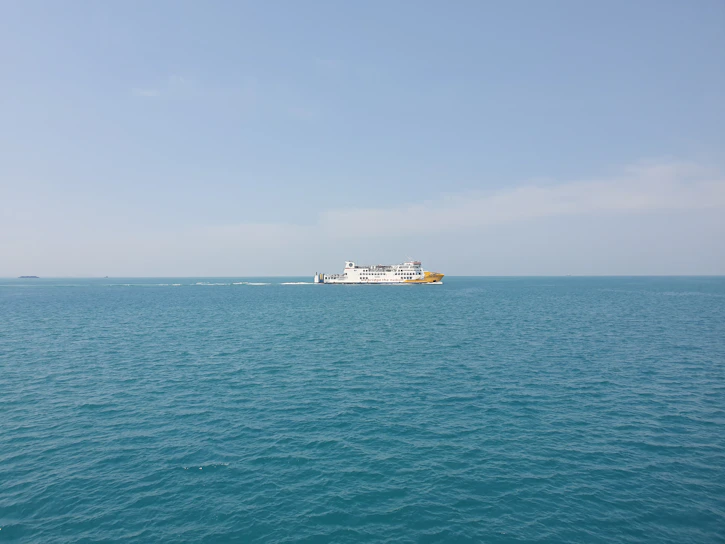 A sleek automated ferry gliding smoothly across calm waters under a clear sky.