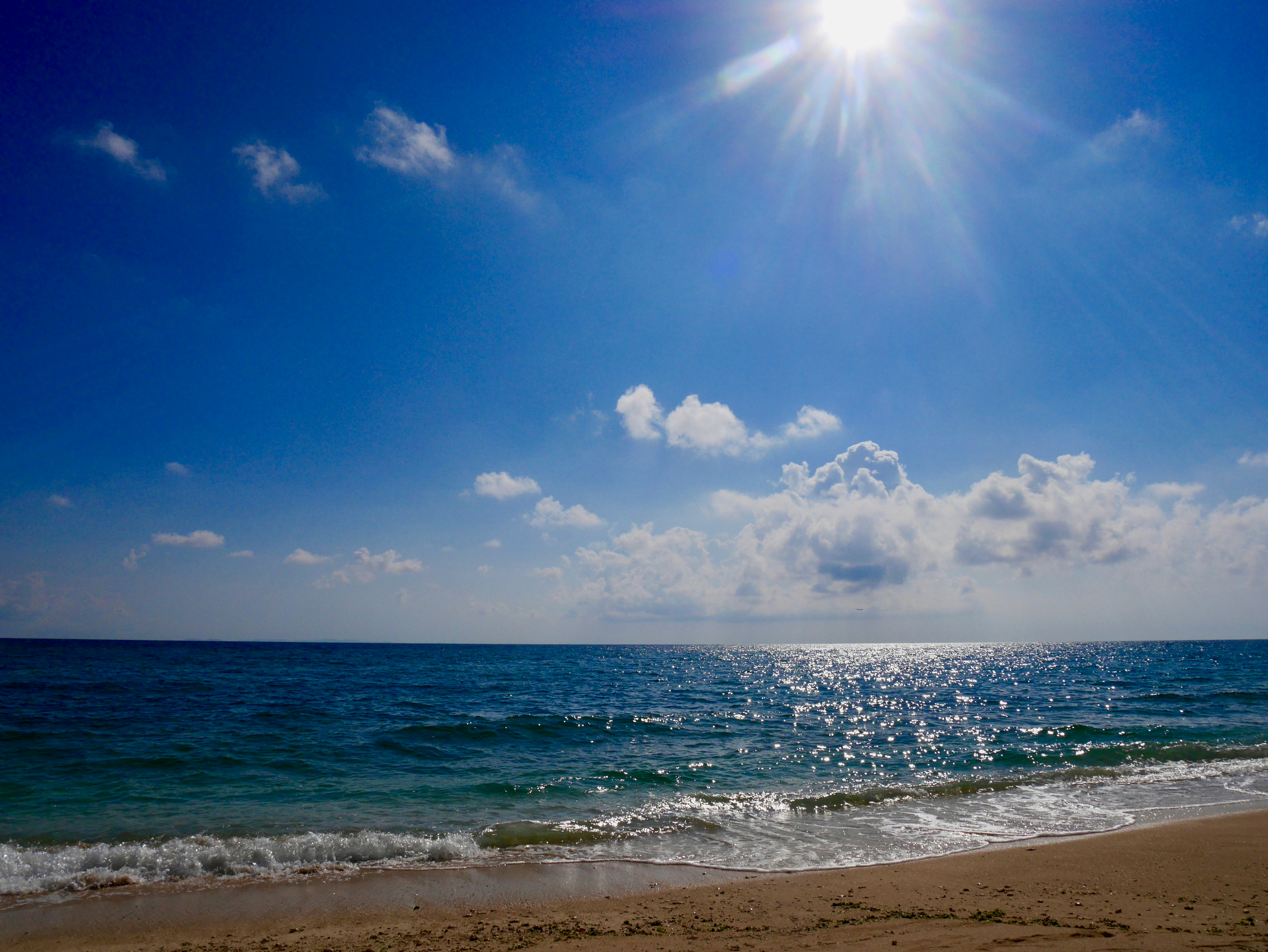 blue sea under blue sky and white clouds during daytime