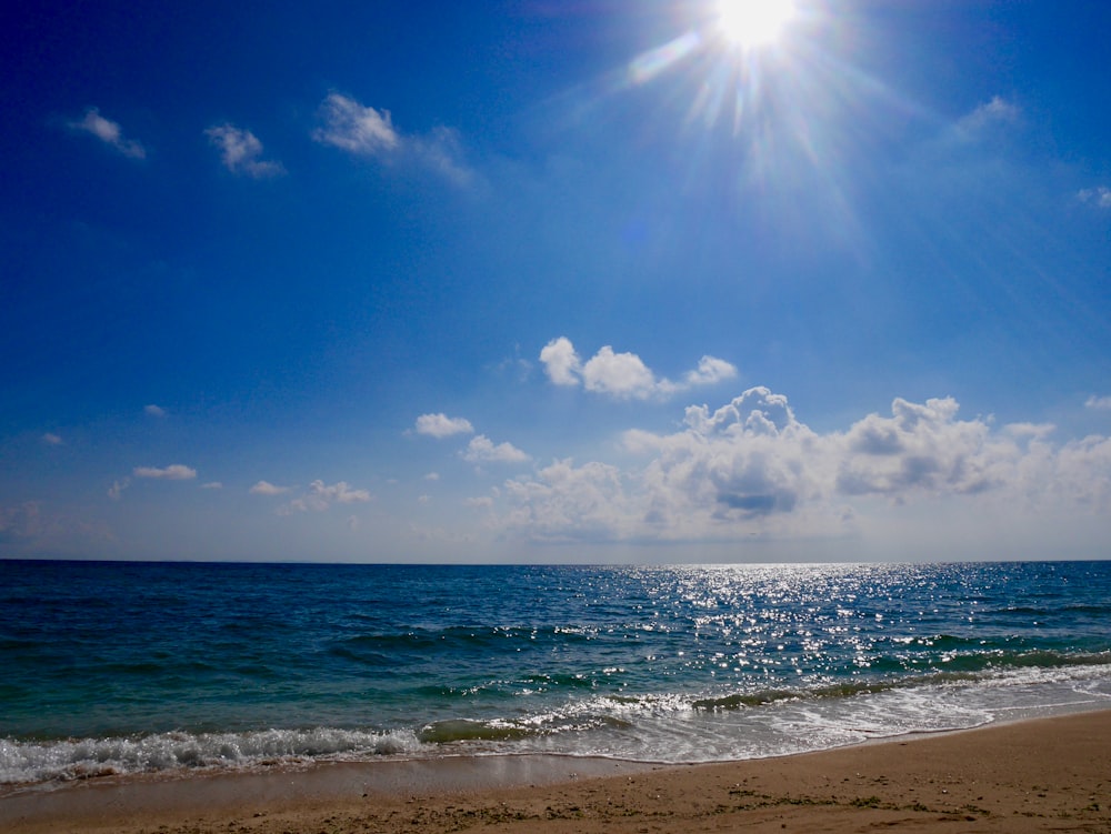 blue sea under blue sky and white clouds during daytime